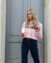 a lady wears a pink cropped wool jacket with dark wash skinny jeans